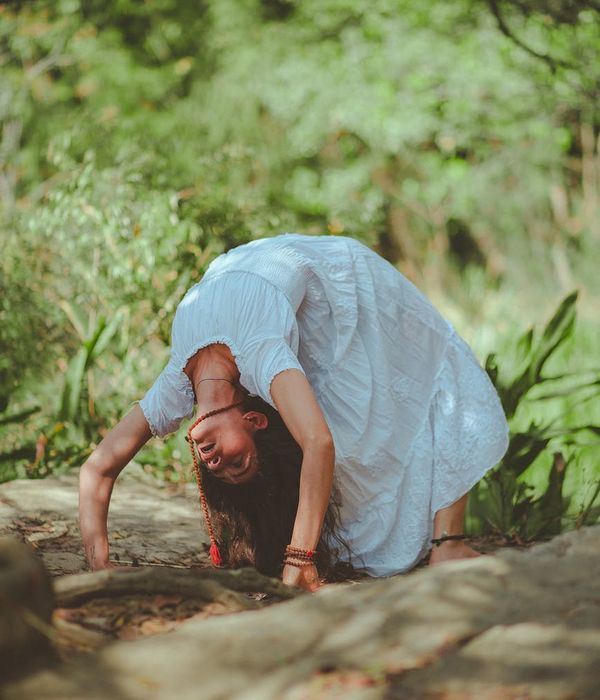 Woman in a calm yoga pose in a dark, serene environment.